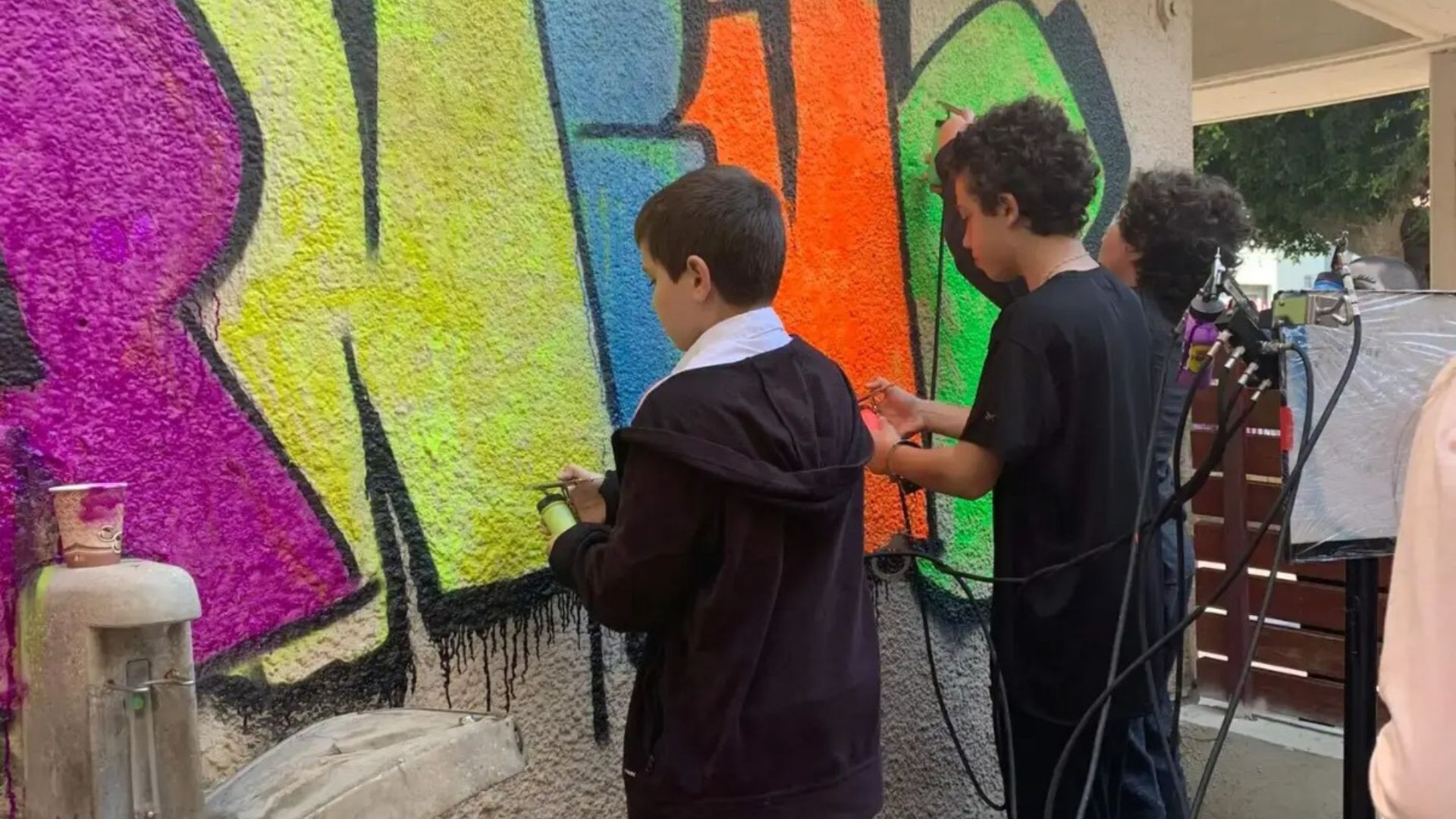 ילדים ליד קיר גרפיטי